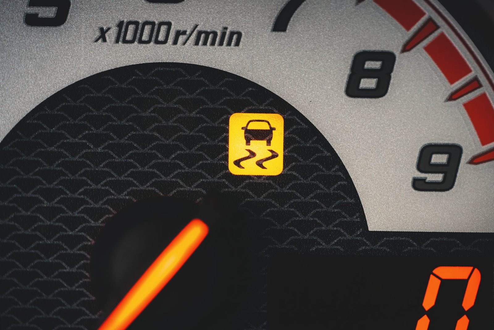 A tachometer needle high in the rev range with a warning light lit