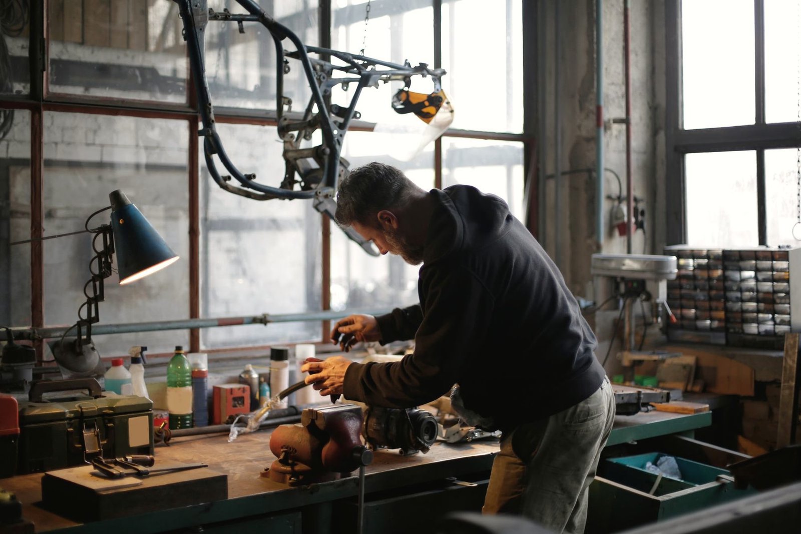 A mechanic at a workbench under a lamp