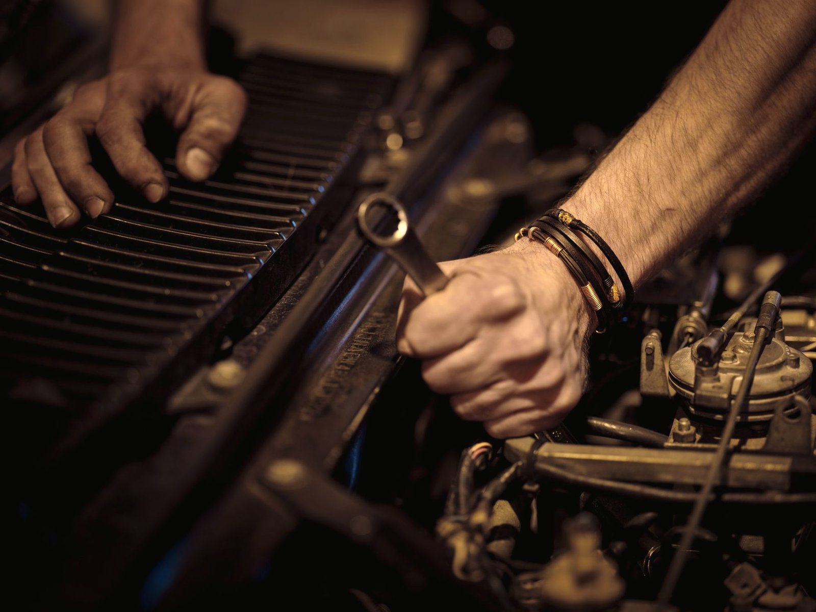 Hands using a wrench on an engine